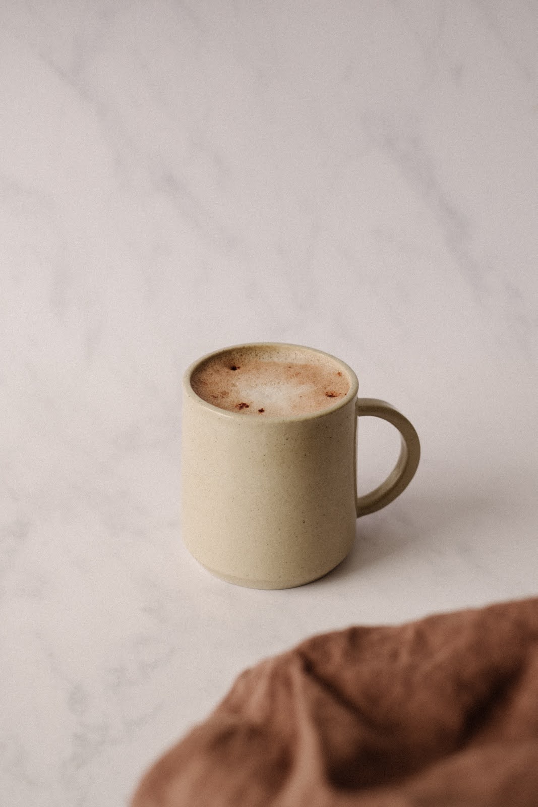 Boisson à base de la poudre collagène MamaLoad de Jolly Mama dans une tasse posée sur une table.